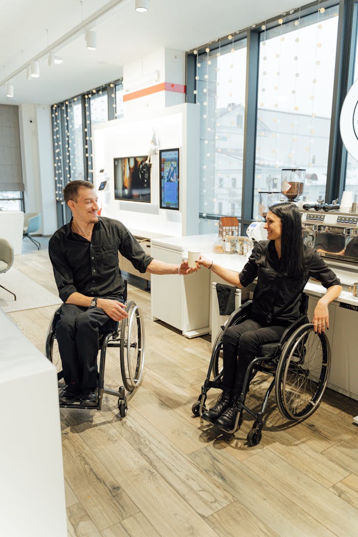 gallery-3 Happy moment in a modern cafe as two friends in wheelchairs share a coffee exchange.