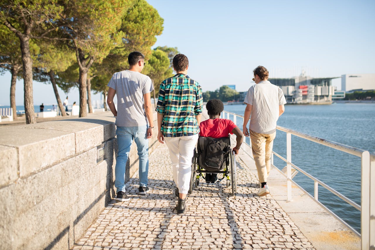 gallery-2 Four friends enjoying a sunny day by the seaside, with one using a wheelchair, in Portugal.